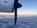 Rotating propeller of an airplane flying above the clouds in the sunset sky Royalty Free Stock Photo