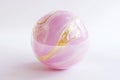 rotating sphere in pink, with delicate gold veins running through it, creating an elegant design