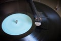 Rotating vinyl record with blue label on a turntable close-up Royalty Free Stock Photo