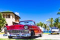 American red and blue white vintage car parked on the beach in Varadero Cuba - Serie Cuba Reportage