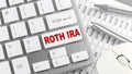 ROTH IRA text on a keyboard wirh chart and pencil