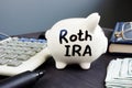 Roth IRA written on a piggy bank. Retirement plan.