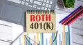 ROTH 401K written on a notepad with office tools,business concept