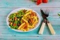 Rotini pasta and arugula salad with strawberry and pistachios on blue table Royalty Free Stock Photo