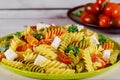 Rotini pasta and cherry tomato with green salad on wooden table Royalty Free Stock Photo