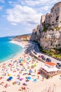 Rotonda beach full of people. Amazing Italian beaches. Sea promenade scenery in Tropea with high cliffs with built on top city