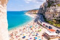 Rotonda beach full of people. Amazing Italian beaches. Sea promenade scenery in Tropea with high cliffs with built on top city