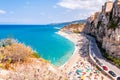 Rotonda beach full of people. Amazing Italian beaches. Sea promenade scenery in Tropea with high cliffs with built on top city