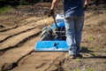 Rototiller tractor unit preparing soil dirt on outdoor garden
