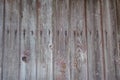 Rotted fence boards with traces of burgundy paint, knots and screw caps, background Royalty Free Stock Photo