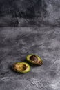 Rotten avocado, half sliced fruit, freegan food concept, grey background Royalty Free Stock Photo