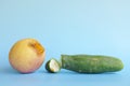 Rotten, bruised, stale or bad apple and cucumber isolated in blue background. Food waste and poor agricultural crop quality concep