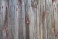 Rotten fence boards with traces of burgundy paint, knots, background Royalty Free Stock Photo