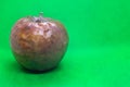 Rotten granny smith apple on green background Royalty Free Stock Photo