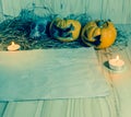 rotten Halloween pumpkin and old paper with candlelight and dry Royalty Free Stock Photo