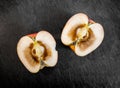 Rotten inside of an apple, cut in half and resting on top of dark cutting board. Royalty Free Stock Photo