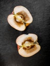 Rotten inside of an apple, cut in half and resting on top of dark cutting board. Royalty Free Stock Photo