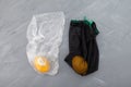 Rotten lemon fruit in plastic bag, fresh lemon in a mesh eco-bag for storing vegetables. Improper food storage. Reduction of Royalty Free Stock Photo