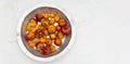 Rotten, spoiled apples and tangerines on an iron pan on a white background