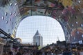 Artwork at the wall of the Markthal and a view to the pencil building through the glass