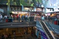 Interior view of busy shopping mall with escalators