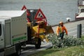 Man in orange working boiler suit and helmet inserting  branches of tree into high capacity wood chipper Royalty Free Stock Photo