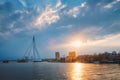 Rotterdam skyline cityscape with Erasmusbrug bridge over Nieuwe Maas in contre-jur on sunse, Netherlands.