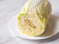 The rotting inside a fresh napa cabbage. Rotten chinese cabbage on a plate close-up. The head of cabbage spoils from the inside.