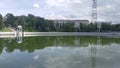 A rotunda of concrete columns with a domed roof stands on the bank of the water channel. Nearby are stairs, trees on grass lawns, Royalty Free Stock Photo