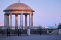 Rotunda and lighthouse on the embankment in the red rays of the rising sun. Summer morning. No people. transparent dome Royalty Free Stock Photo