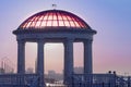 Rotunda with a transparent dome on the city embankment of the Amur River. The morning sun painted the roof of the gazebo Royalty Free Stock Photo