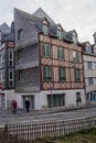 Rouen. Old and tilted houses at Rue Eau de Robec on a rainy day. Rue Eau-de-Robec is one of the main tourist streets of