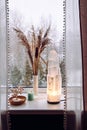 Rough big selenite crystal tower lamp illuminated on home window sill, spiritual home decor accent.
