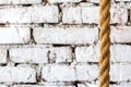 Rough braided rope against the background of a white brick wall in luxury loft interior of a hotel room