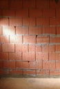 Rough brick wall from Porotherm style clay blocks in a construction site laterally lit, architecture background with copy space,