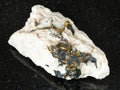 rough Chalcopyrite crystals in rock on black