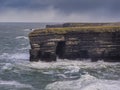 Rough coastline with cliffs and green grass field. Kilkee, county Clare, Ireland. Beautiful Irish nature scenery. Popular travel Royalty Free Stock Photo