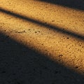 Rough concrete surface illuminated by sunlight, casting long, diagonal shadows. The Royalty Free Stock Photo