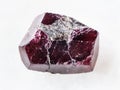 rough crystal of red garnet gemstone on white