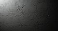 Rough, dark, textured wall surface with uneven patterns and shadows. The material appears to be Royalty Free Stock Photo