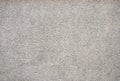 A rough-finished surface of a light gray natural stone with close-up traces of grinding Royalty Free Stock Photo