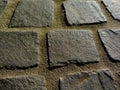 rough gray cobblestone pavement detail in closeup view. granite stone road surface.