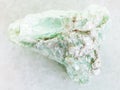 rough green talc stone on white marble