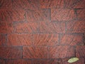 Rough hewn chiseled red brick wall for abstract, textured background.