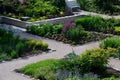 Rough-hewn limestone stones on the paving of a path in a park above a regularly shaped pond. tralk beds around. gray and brown mix