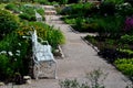 Rough-hewn limestone stones on the paving of a path in a park above a regularly shaped pond. tralk beds around. gray and brown mix