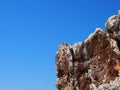 Rough jagged rocky outcrop against a bright blue sunlit sky