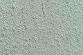 Rough plaster wall, light mint green color, scratched surface, background