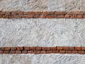 Rough plaster wall texture with rows of exposed antique red bricks, Royalty Free Stock Photo