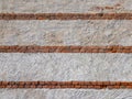 Rough plaster wall texture with three rows of exposed antique red bricks Royalty Free Stock Photo